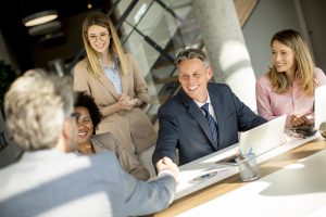 Business people shaking hands by the desk in the office